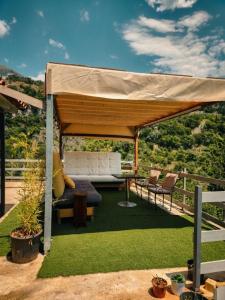 a gazebo with a couch and chairs under it at Vila zaho in Dhërmi