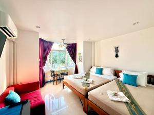 a hotel room with two beds and a couch at Kelly Hotel Bangsean in Ban Laem Thaen +110 photos