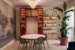 a dining room with a table and chairs and a plant at B&B HOTEL Pesaro Des Bains in Pesaro