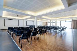 a large room with chairs and a projection screen at B&B HOTEL Expo Verona Villafranca in Villafranca di Verona