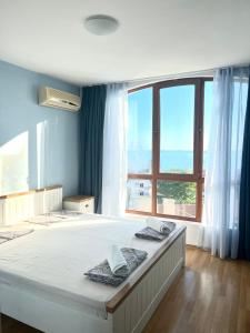 a large bed in a room with a large window at Triumph Fantastic View in Sveti Vlas +23 photos