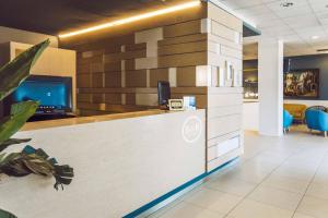 an office with a reception desk with a computer on it at B&B HOTEL Mantova Cristallo in Virgilio
