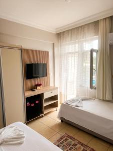 a bedroom with two beds and a flat screen tv at jasmine otel in Kemer +7 photos