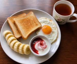 a plate with eggs and toast and a cup of coffee at La casa Cottage in Iringa