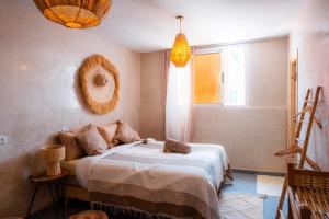 a bedroom with a bed and a window at Little Palm Camp in Imsouane