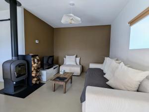 a living room with a couch and a wood stove at Grange rénovée - Calme et Vue sur les volcans in Saint-Just-près-Brioude