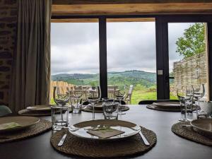a table with wine glasses and a view of the mountains at Grange rénovée - Calme et Vue sur les volcans in Saint-Just-près-Brioude