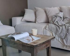 a coffee table with a book on it next to a couch at Grange rénovée - Calme et Vue sur les volcans in Saint-Just-près-Brioude