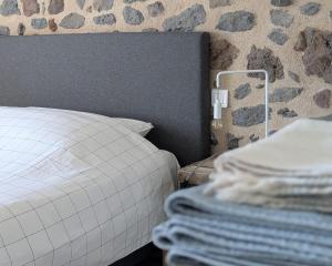 a bedroom with a bed and a pile of towels at Grange rénovée - Calme et Vue sur les volcans in Saint-Just-près-Brioude +18 photos