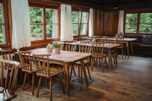 a dining room with tables and chairs and windows at Wannenkopfhütte in Obermaiselstein