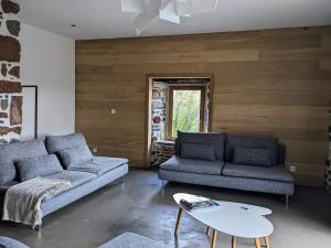 a living room with two couches and a table at Maison de vacances tout Confort au Calme avec Jardin clos in Saint-Just-près-Brioude