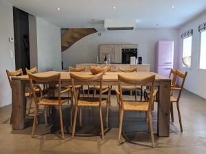 a wooden table and chairs in a kitchen at Maison de vacances tout Confort au Calme avec Jardin clos in Saint-Just-près-Brioude
