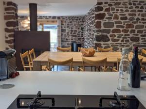 a kitchen with a stove and a table with chairs at Maison de vacances tout Confort au Calme avec Jardin clos in Saint-Just-près-Brioude