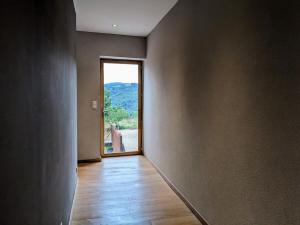 an empty room with a large window and a wooden floor at Maison de vacances tout Confort au Calme avec Jardin clos in Saint-Just-près-Brioude +16 photos