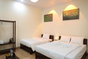 a bedroom with two beds and a mirror at Tan Ca Home & Studio Ninh Bình in Kỳ Vĩ