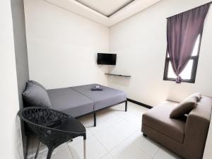 a small living room with a bed and a couch at NamRoom at Kalimalang in Cibening