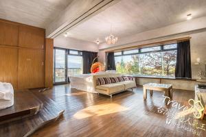a large room with a bed and a couch in it at 建築師湧泉泡湯會館 in Dongshan