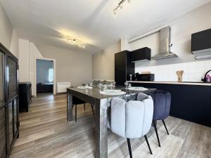 a kitchen and dining room with a table and chairs at Le Cosy Industriel in Le Puy-en-Velay