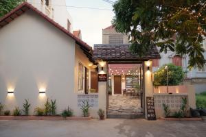 a white house with a pathway leading to the front door at Tan Ca Home & Studio Ninh Bình in Kỳ Vĩ
