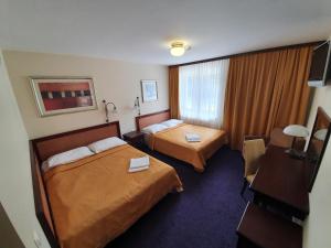 a hotel room with two beds and a window at Dwór Zielone Wzgórza in Bukowno