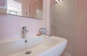 a white bathroom with a sink and a mirror at Lungomare Casa Diaz in Cagliari