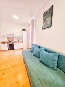a blue couch in a living room with a kitchen at Apartmán Lotta in Kežmarok