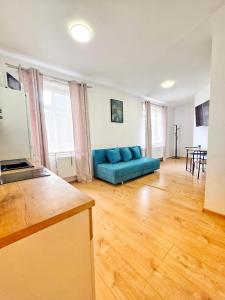 a living room with a blue couch and a table at Apartmán Lotta in Kežmarok