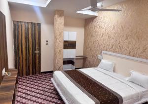 a bedroom with a large bed in a room at Shree ji Hotel and Resort in Ujjain