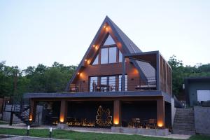 a large wooden house with a roof at Colina Monteoru in Sărata-Monteoru