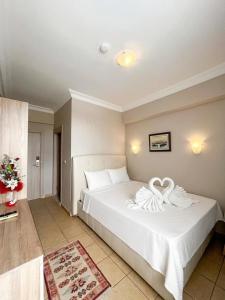 a bedroom with a white bed with a heart decoration on it at jasmine otel in Kemer