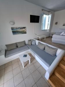 a living room with a long couch and a table at Solaris in Chora Folegandros