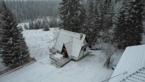a house with a snow covered roof in a forest at Planinski vrh in Bajina Bašta +6 photos