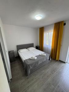 a bedroom with a bed with two towels on it at Casa Osan in Tăşnad