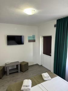 a room with a bed and a flat screen tv at Casa Osan in Tăşnad +4 photos