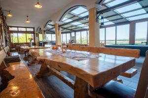 a dining room with wooden tables and large windows at Vila Ribič in Železnička Stanica Žejinci