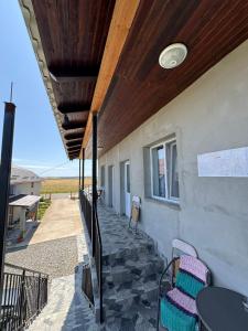 a porch of a house with a table and chairs at Casa Osan in Tăşnad
