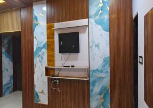 a room with a wall with a tv on it at Shree ji Hotel and Resort in Ujjain