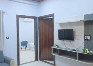 a living room with a television on a wall at Shree ji Hotel and Resort in Ujjain