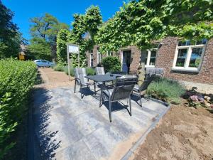 a patio with a table and chairs in front of a building at B&B de Pottenbakkershoeve in Meerlo