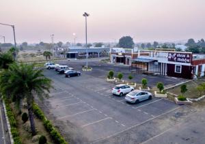 a parking lot with cars parked in front of a building at Shree ji Hotel and Resort in Ujjain