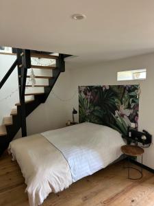 a bedroom with a bed and a staircase at Chambre d'hôtes bed and breakfast in La Chapelle-Faucher