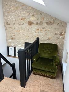 a green chair sitting on the side of a staircase at Chambre d'hôtes bed and breakfast in La Chapelle-Faucher