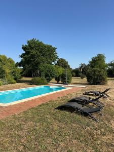 a swimming pool with a boat laying on the grass at Chambre d'hôtes bed and breakfast in La Chapelle-Faucher