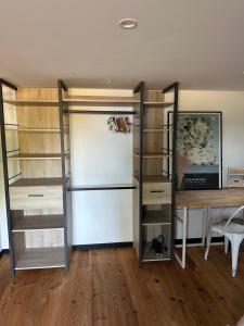 a room with a desk and a closet with shelves at Chambre d'hôtes bed and breakfast in La Chapelle-Faucher +9 photos