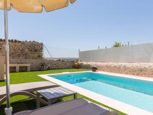 a pool in a backyard with an umbrella and a table and chairs at Casa del Sol in Búger +22 photos