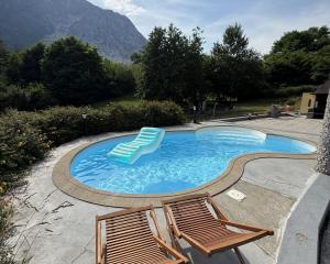 two chairs and a swimming pool with mountains in the background at Il Ranch in Baveno