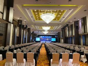 a banquet hall with rows of chairs and a stage at Whiz Prime Hotel Kelapa Gading in Jakarta +41 photos