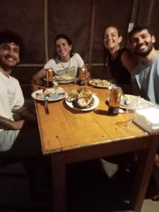 a group of people sitting around a wooden table with food at Ceylon Bay in Arugam Bay +18 photos