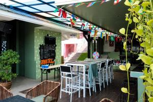 a patio with tables and chairs and flags at Zostel Phuket, Patong Beach Hostel in Patong Beach