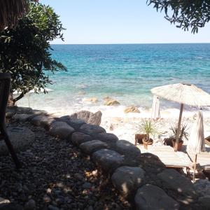 a beach with an umbrella and the ocean at Reževići apartment Lav in Reževići